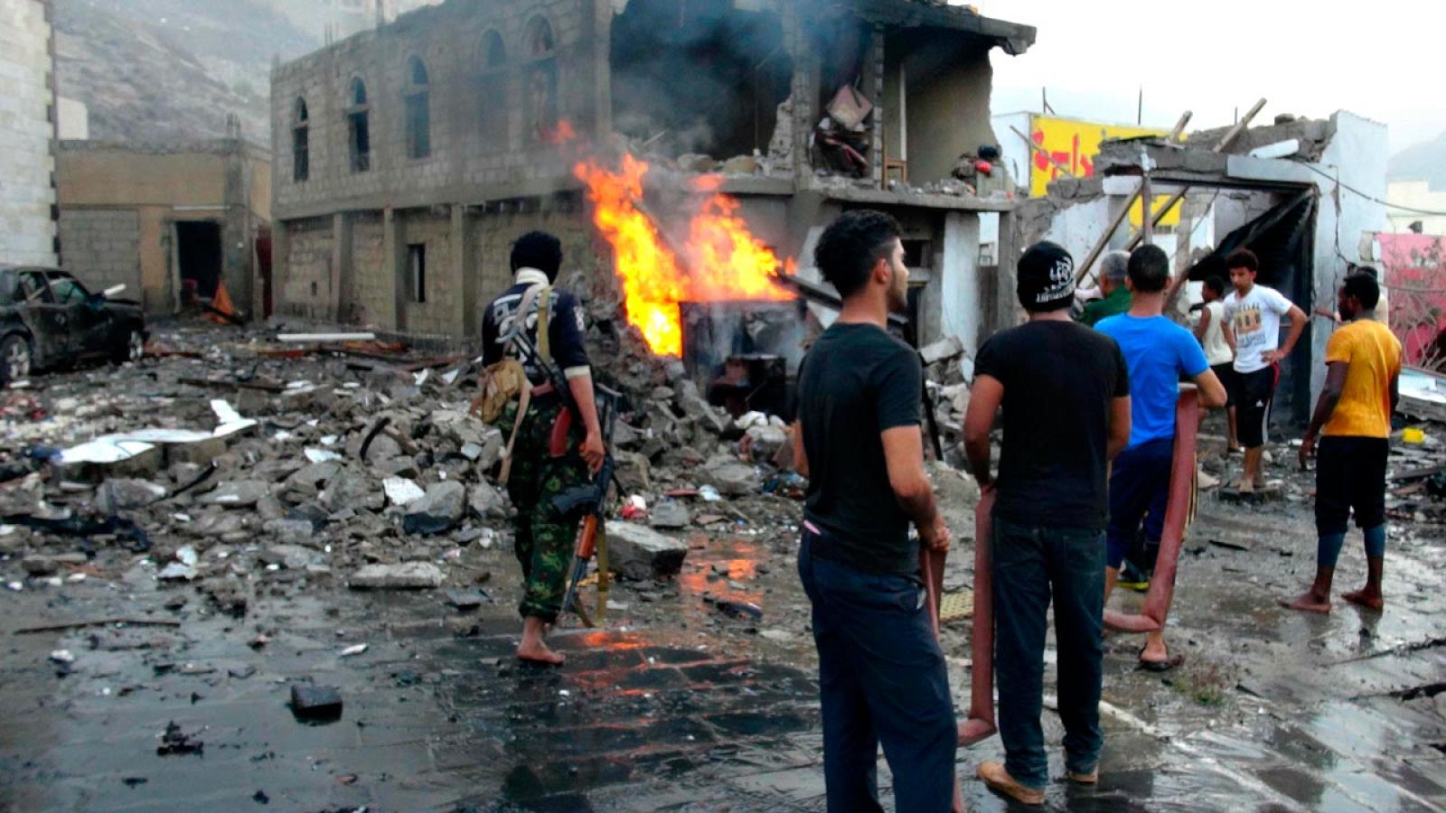 Un grupo de yemeníes observa los destrozos causados por el coche bomba que ha estallado cerca del palacio presidencial de Adén