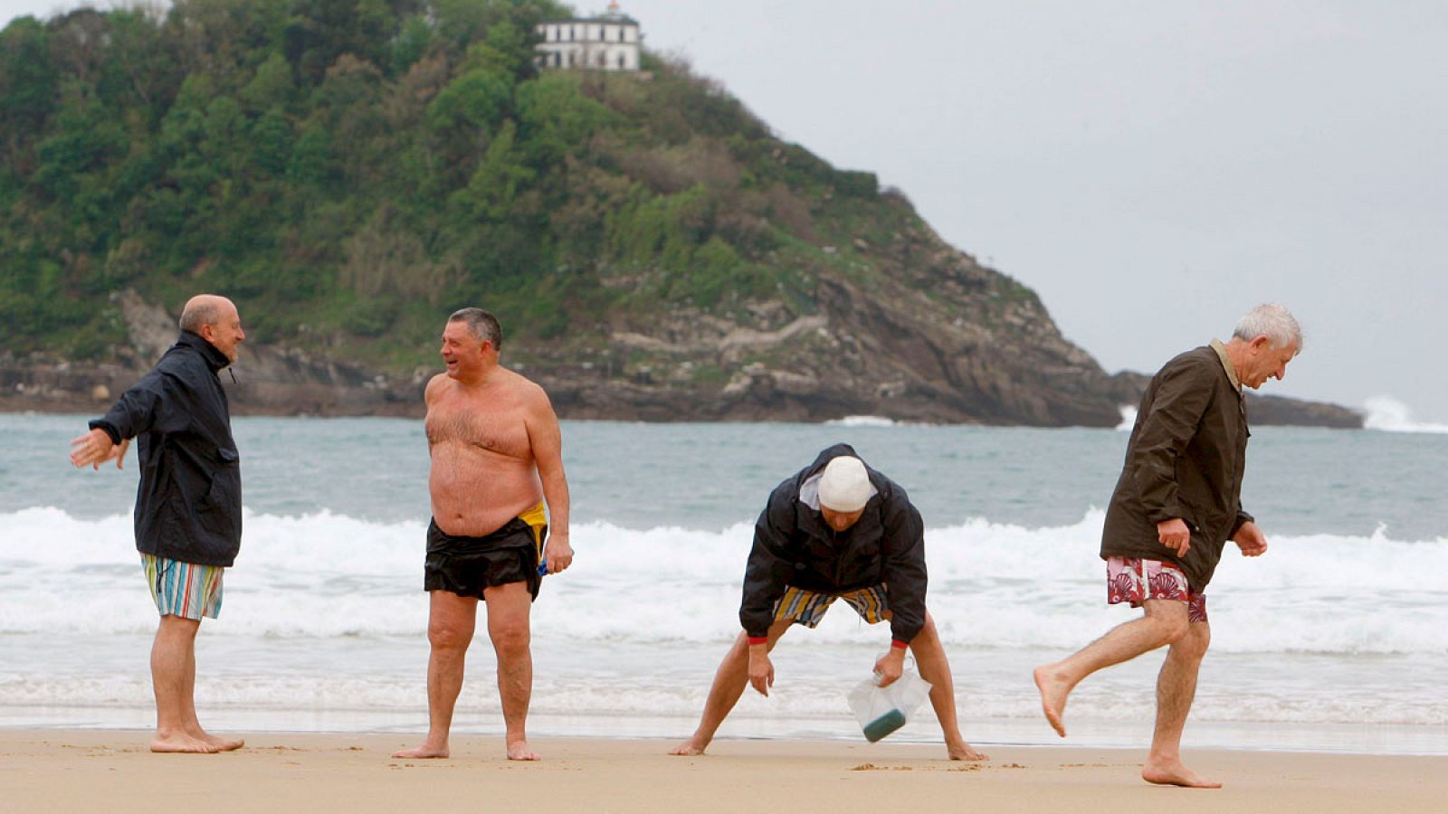Unos jubilados disfrutan de la playa de la Concha en San Sebastián