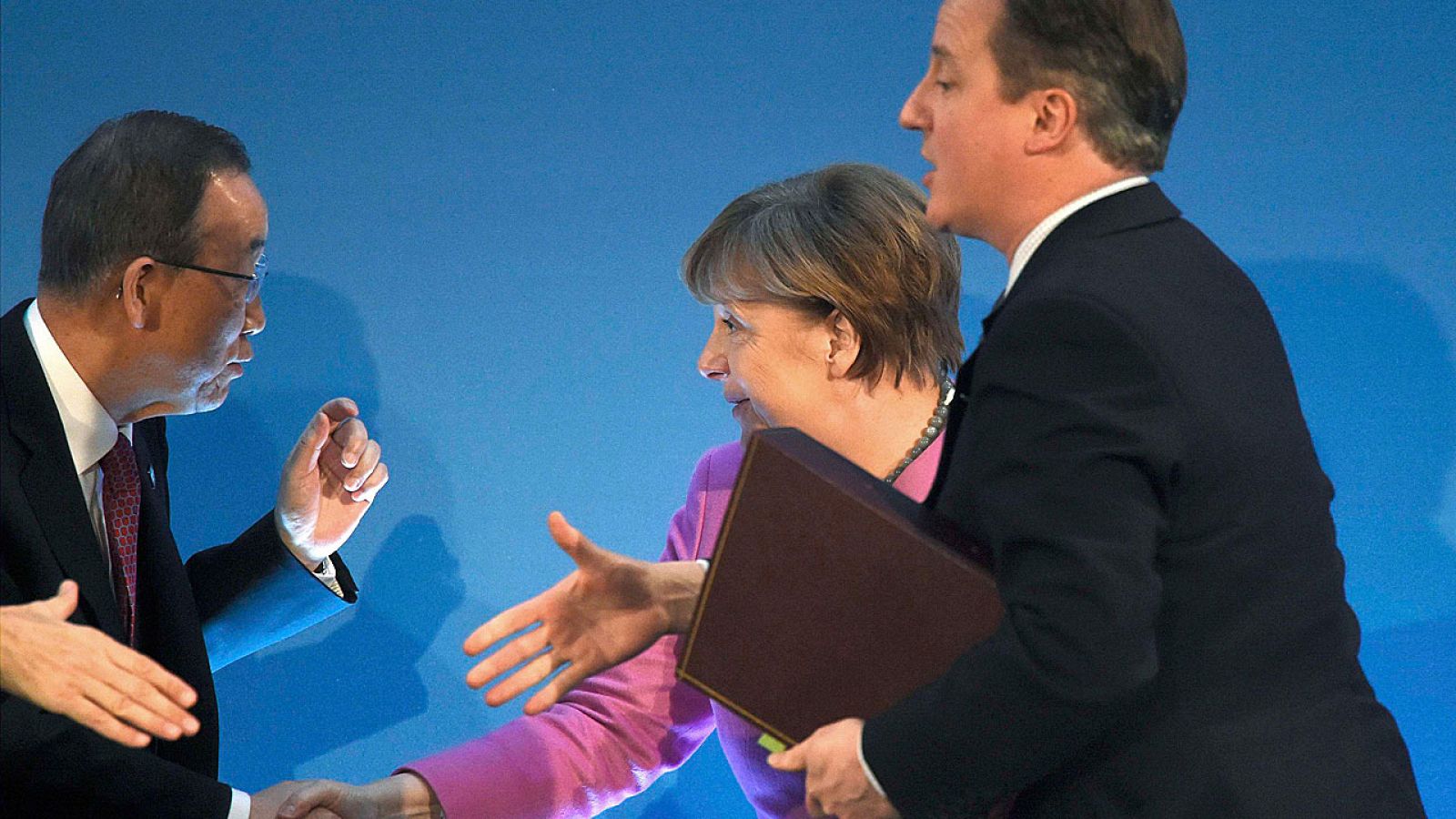 El primer ministro británico, David Cameron, y la canciller alemana, Angela Merkel, saludan al secretario general de la ONU, Ban Ki-moon, durante la conferencia de donantes en Londres.