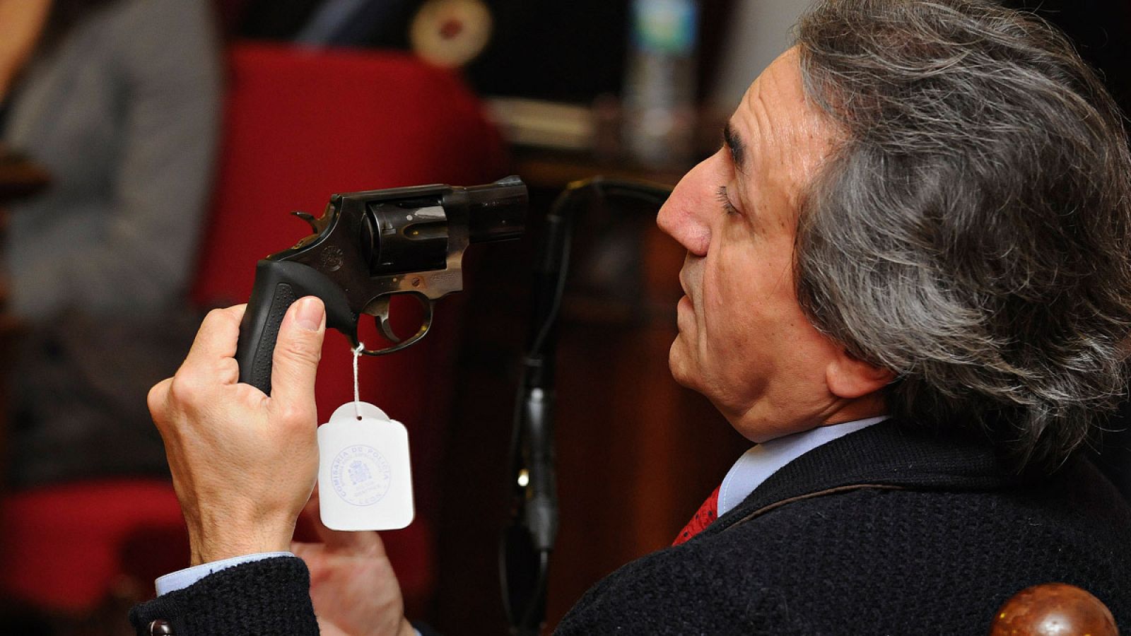 Un agente de la Policía Nacional exhibe un revólver durante su declaración pericial