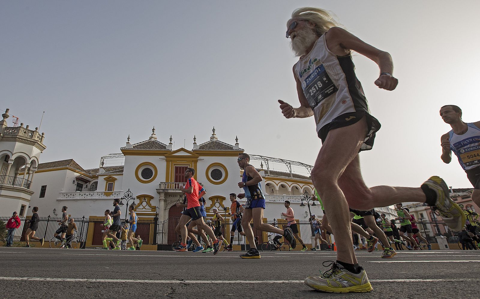Corredores del XXXII Maratón de Sevilla a su paso por la plaza de toros de la Maestranza.