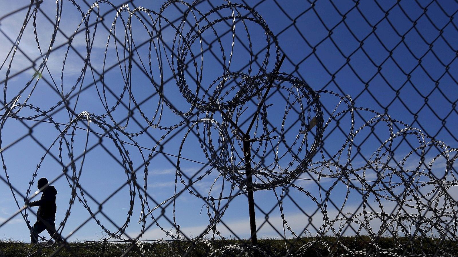 Migrantes junto a la alambrada de la frontera entre Hungría y Serbia