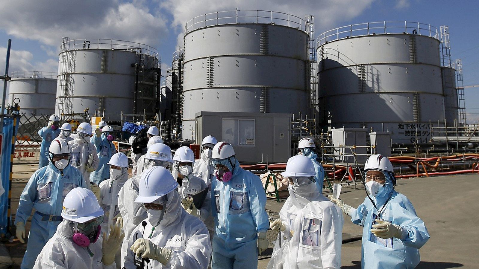 Periodistas protegidos por trajes anti-radiación visitan la central de Fukushima, en Japón