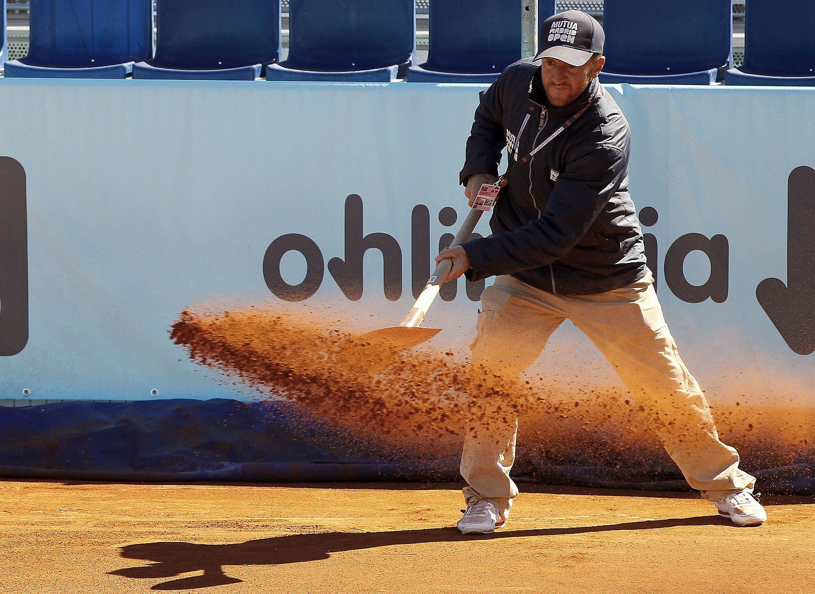 Un operario esparce tierra en las pistas de la Caja Mágica en 2013