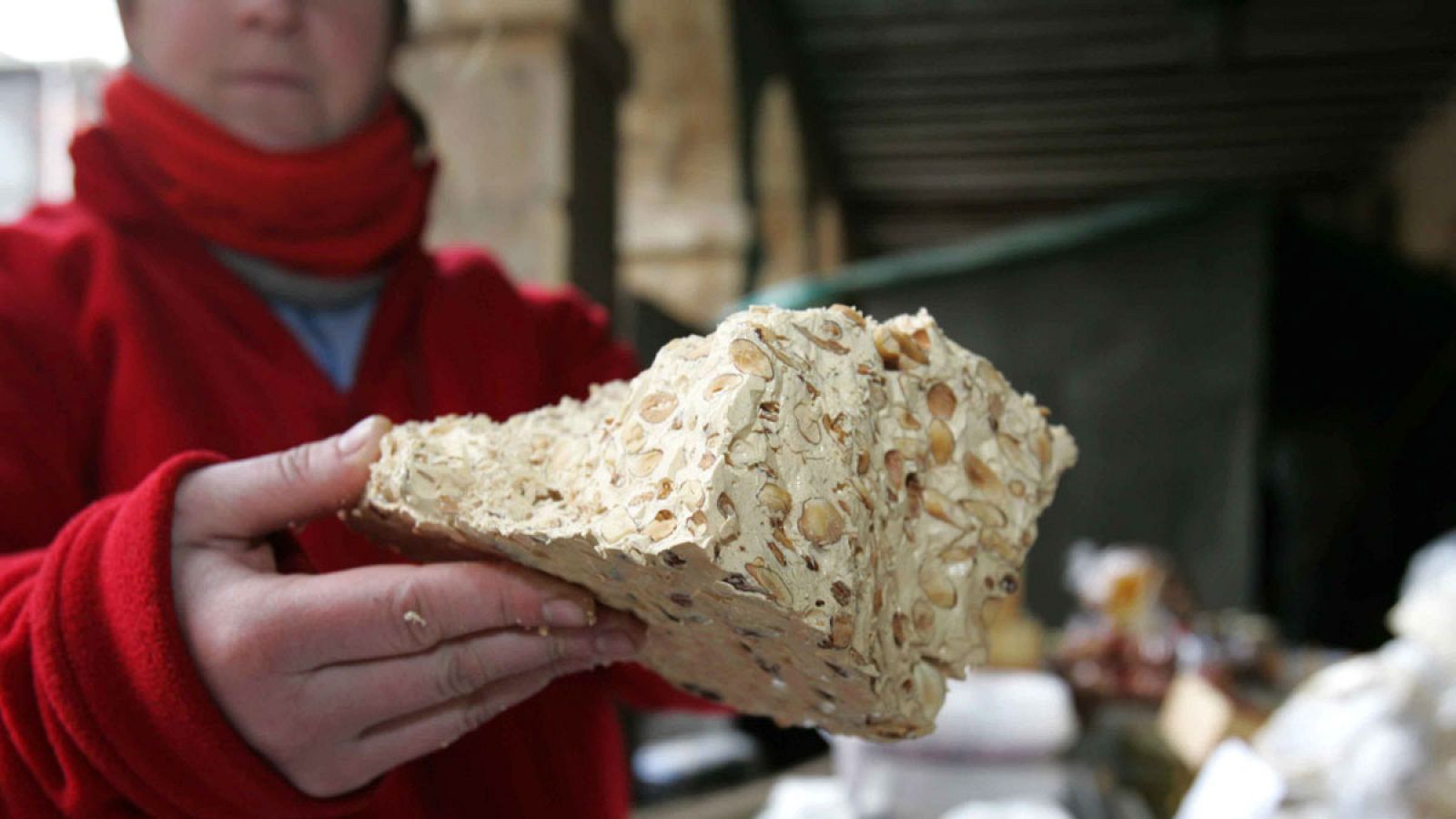 Una mujer muestra un trozo de turrón artesano