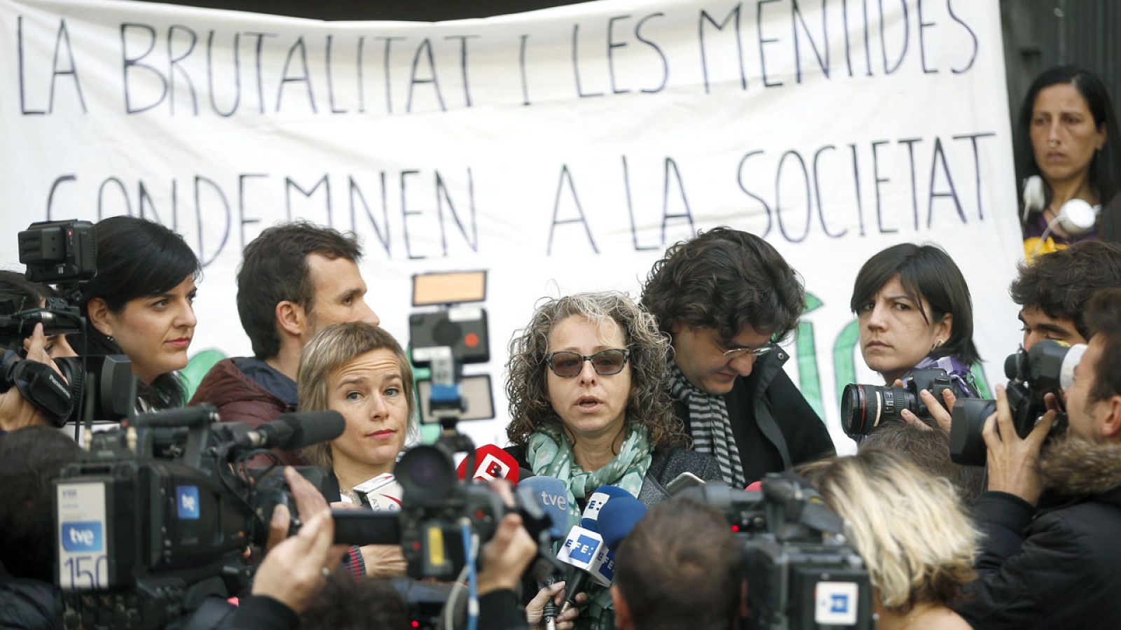 Ester Quintana (c), que perdió un ojo por una pelota de goma de los Mossos, al inicio del juicio