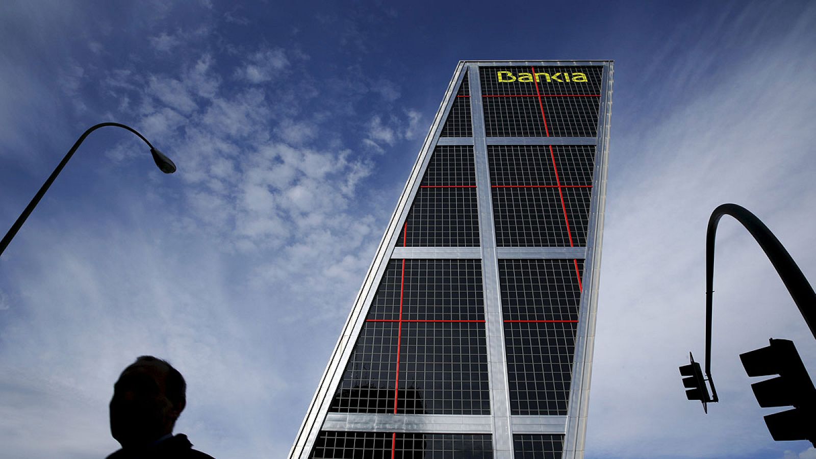 Un hombre junto a la oficina de Bankia en la madrileña Plaza de Castilla