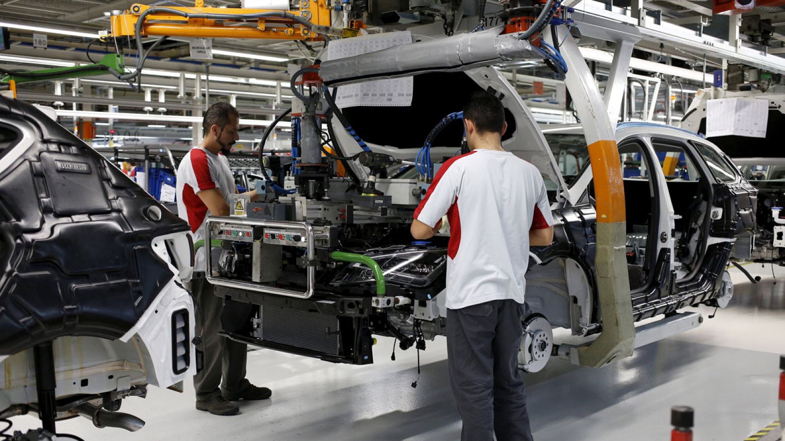 Dos operarios montan el motor de un Seat León en Martorell