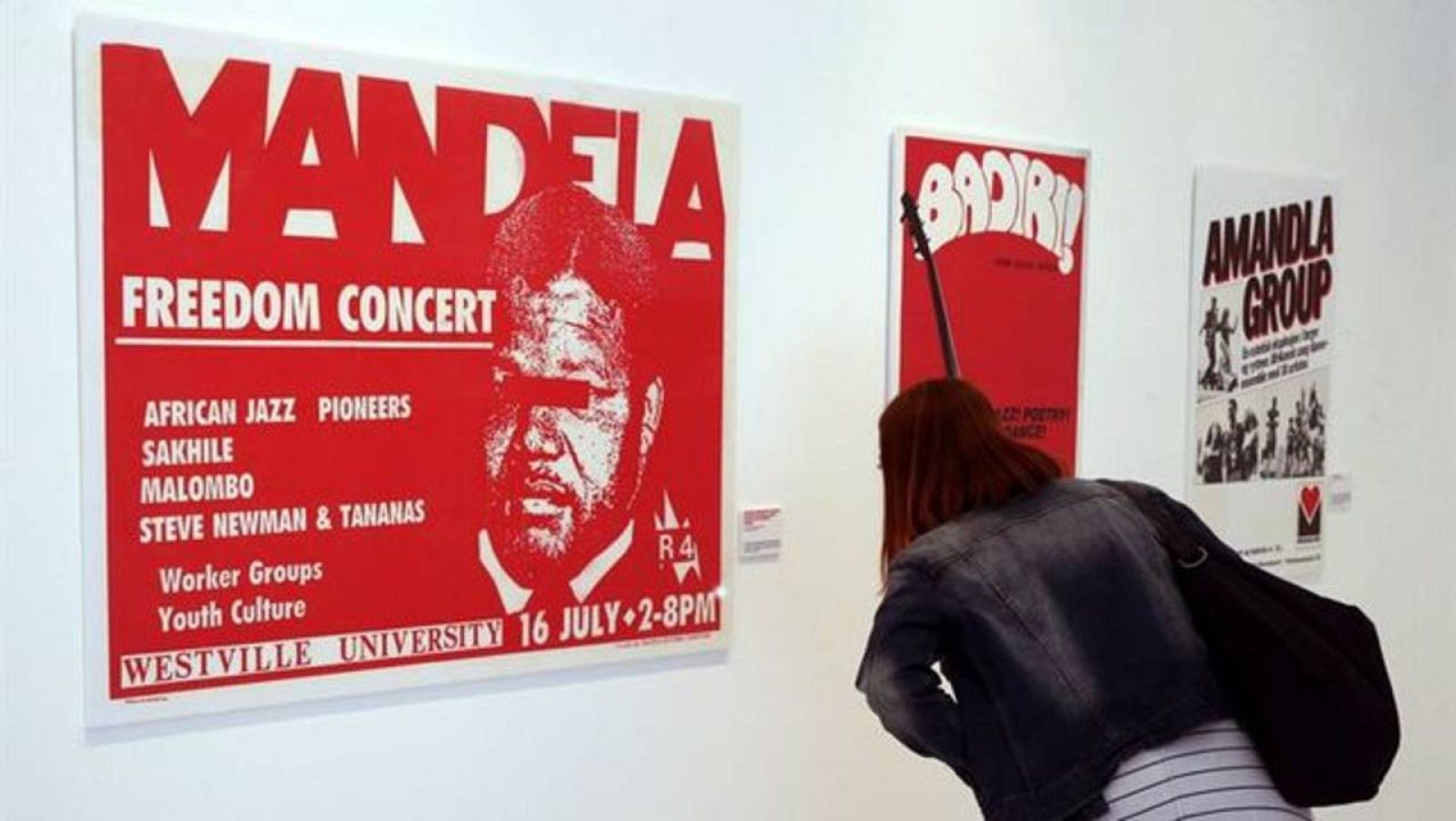 Una mujer observa uno de los carteles de la exposición 'Artivismo'