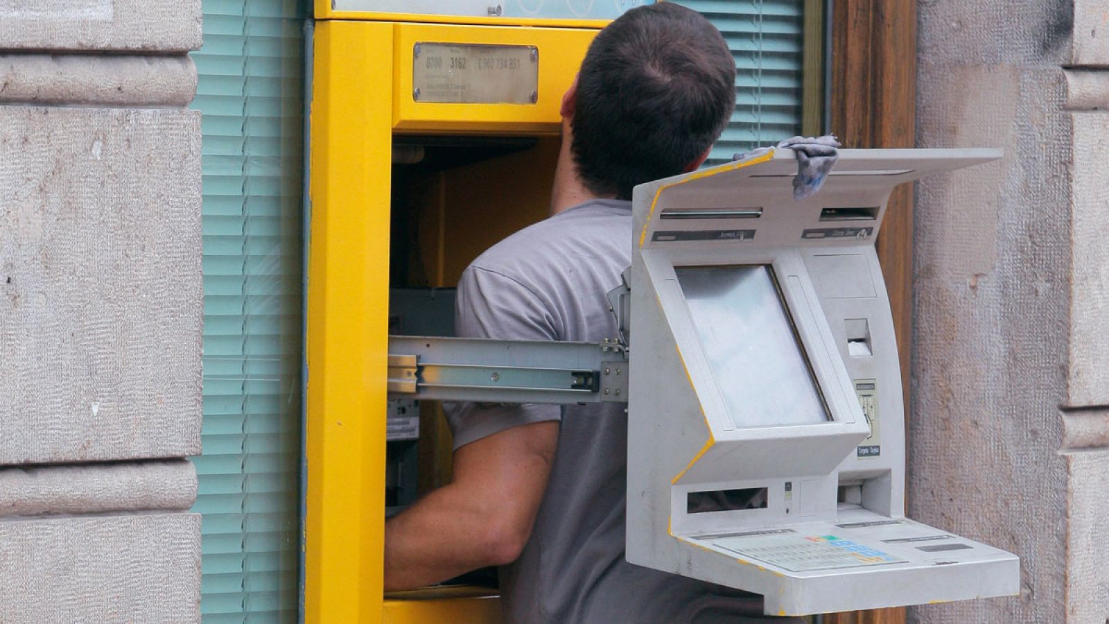 Un técnico arregla un cajero automático