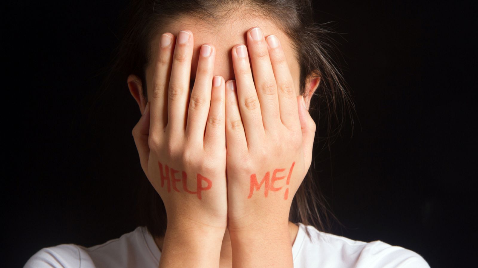 Una mujer se cubre el rostro con las manos