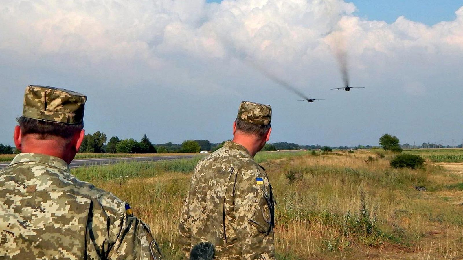 Dos soldados ucranianos observan el vuelo de dos bombarderos Sujoi Su-24 en el este de Ucrania