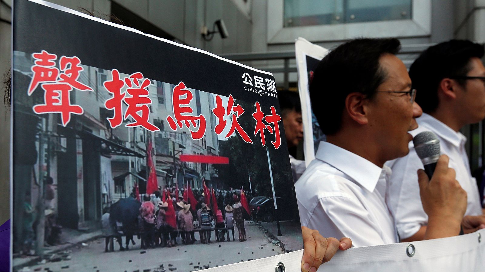 Manifestantes muestran fotografías de la protesta en Wukan durante un acto de apoyo en Hong Kong