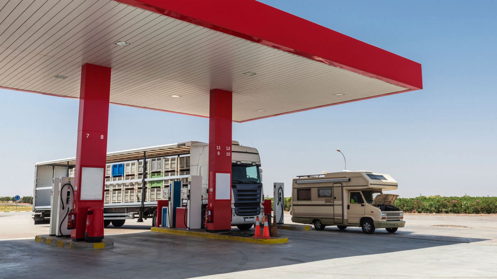 Un camión y una autocaravana repostan en una gasolinera