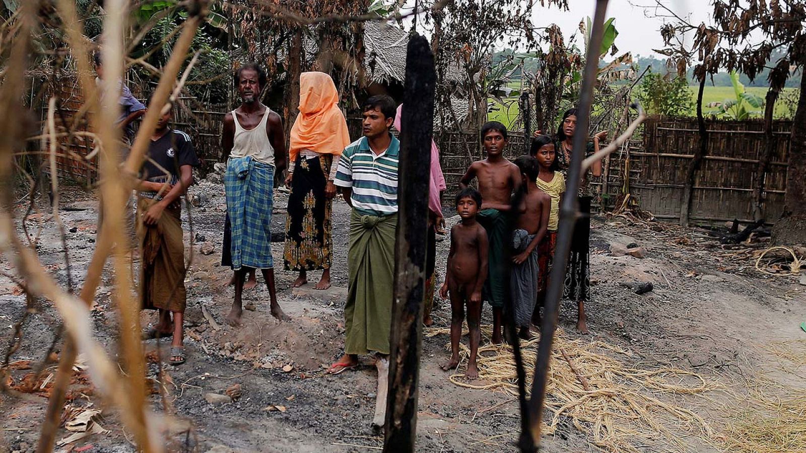 Una familia junto a los restos de un mercado incendiado en una aldea ronhinyá en Maungdaw, estado de Rakáin, en Birmania