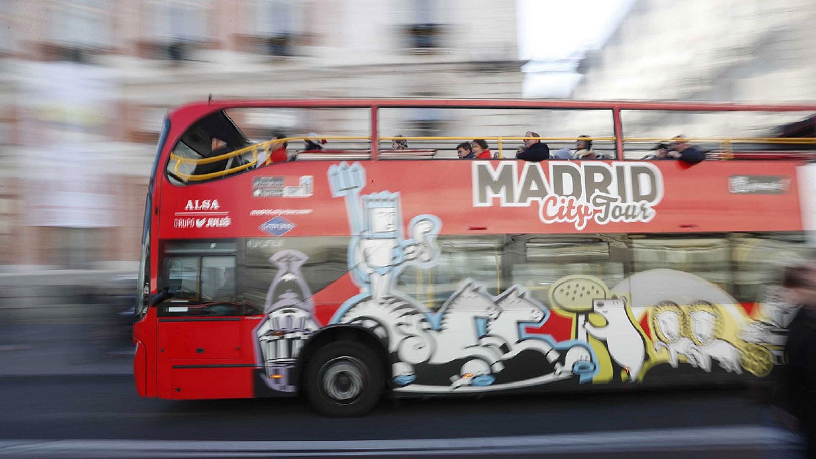 Un autobús turístico circula frente a la madrileña Puerta del Sol