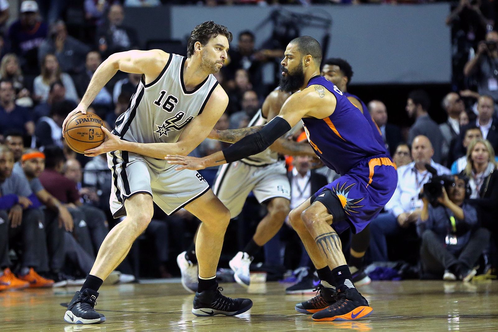 Pau Gasol (16) trata de superar al defensor de los Phoenix Suns Tyson Chandler (4).