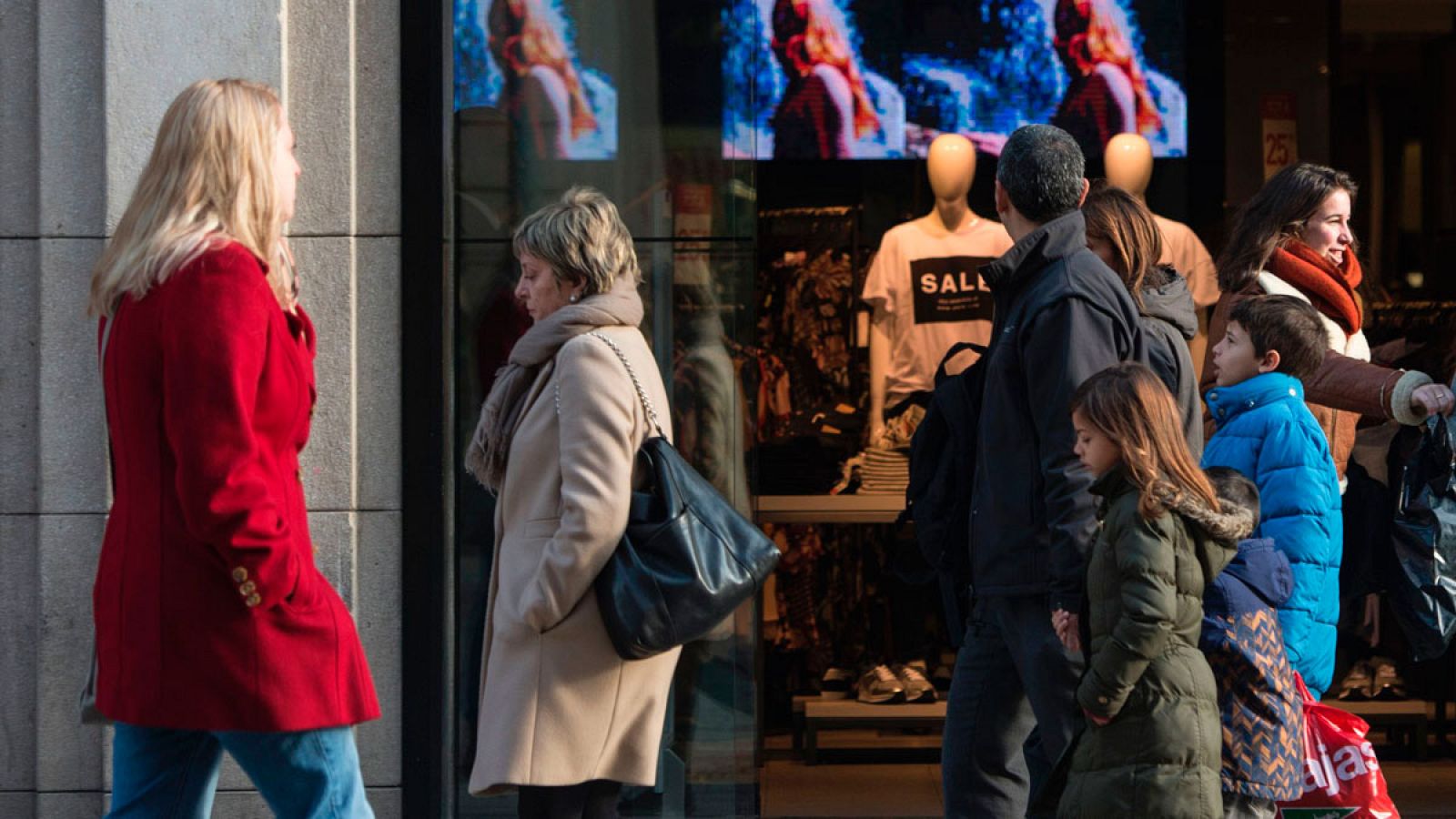 Gente pasando delante de una tienda en Barcelona.