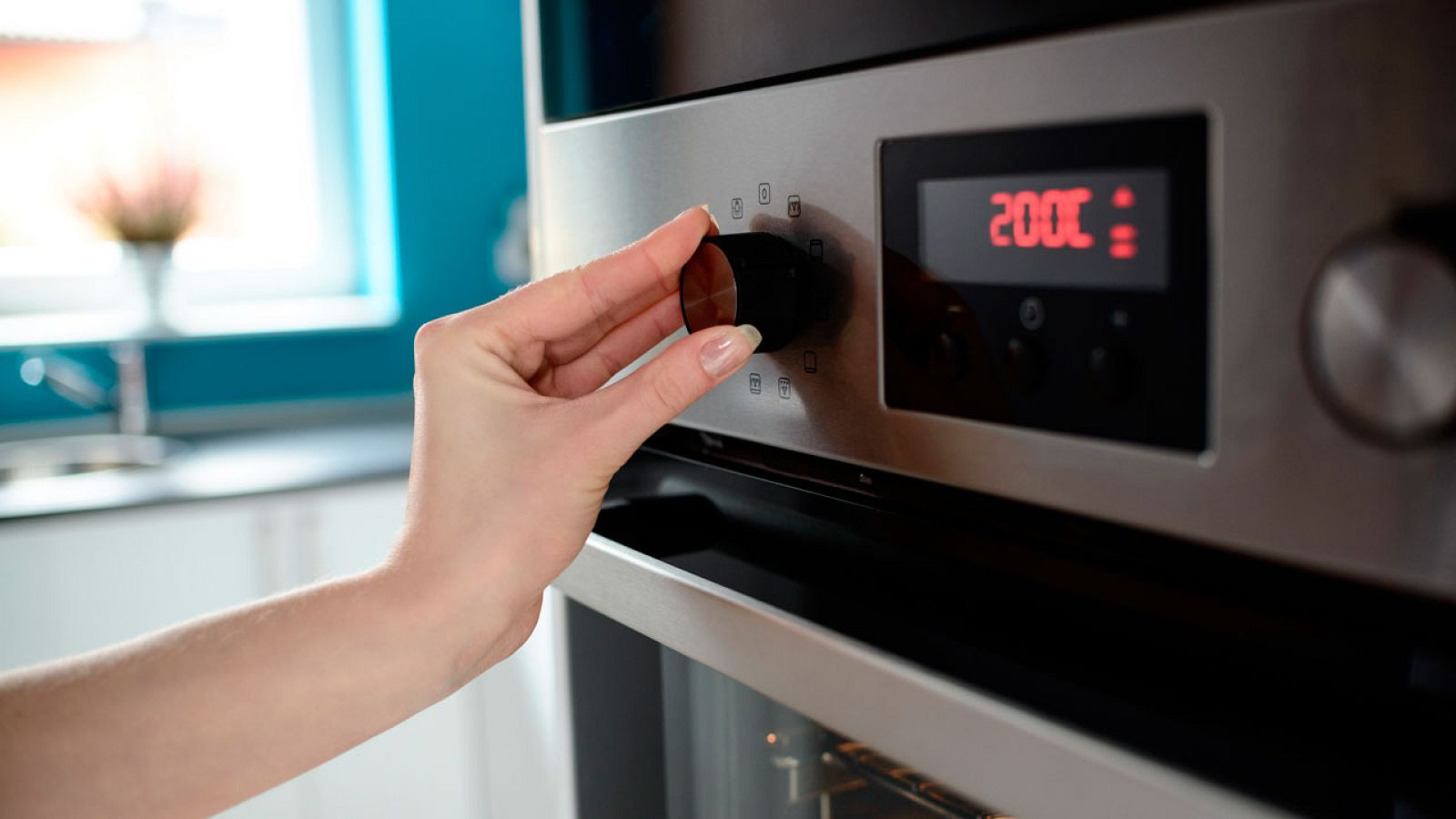 Imagen de archivo de una persona poniendo en su casa el horno eléctrico