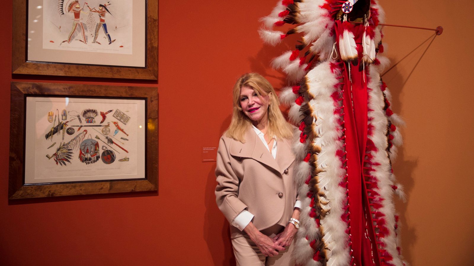La baronesa Carmen Thyssen-Bornemisza posa junto a un penacho indio durante la inauguración de la exposición temporal "La ilusión del Lejano Oeste", en el Museo Carmen Thyssen de Málaga, en 2016