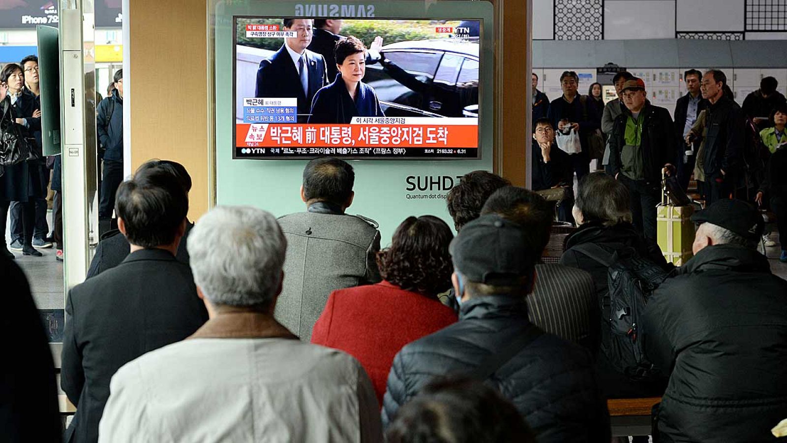 Surcoreanos pendientes de la declaración de la expresidenta Park en una estación de tren en Seúl.