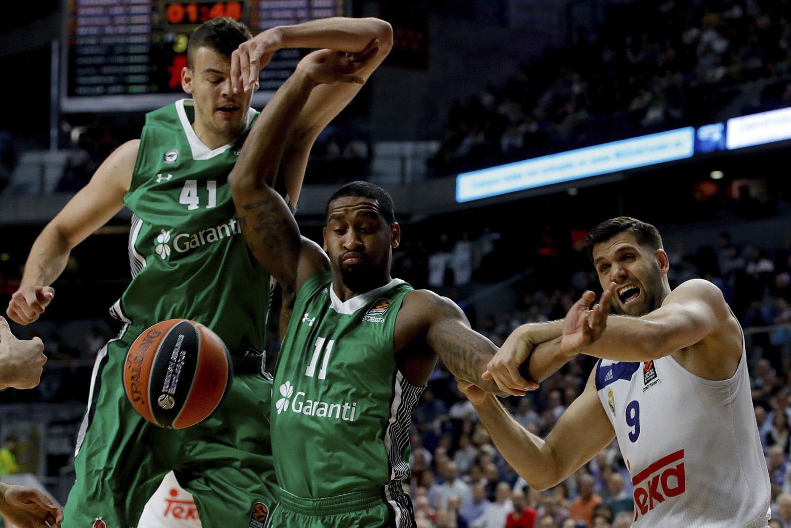 El pivot del Real Madrid Reyes pelea por un balón con los jugadores del Darussafaka Wanamaker (c) y Zizic