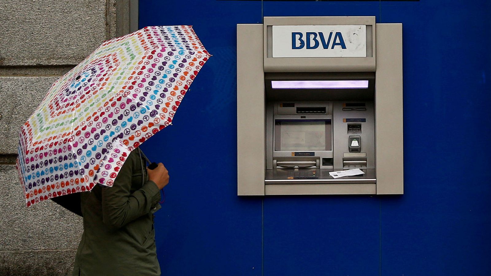 Una mujer pasa por delante de un cajero del BBVA