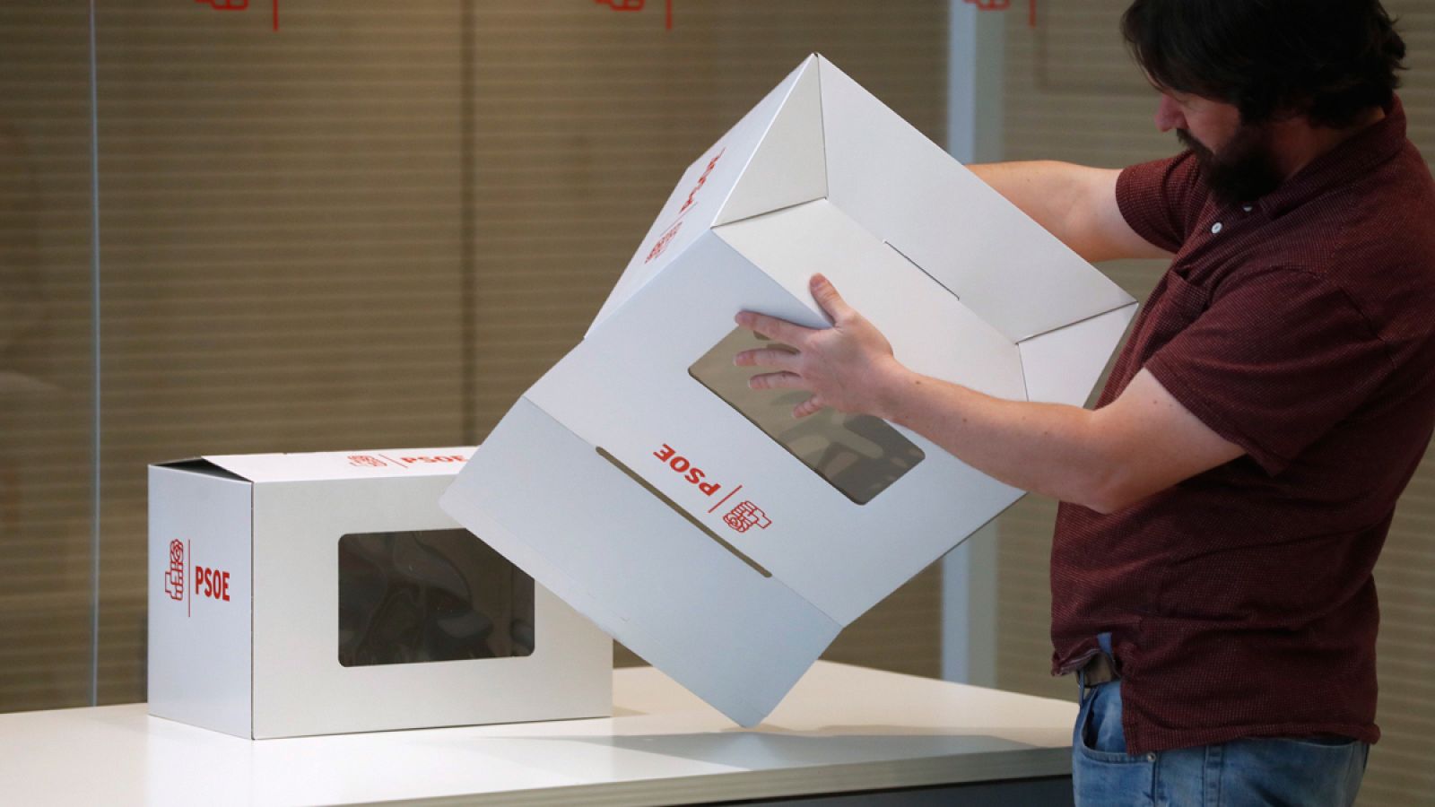 Un operario del PSOE prepara unas urnas en la sede de Ferraz