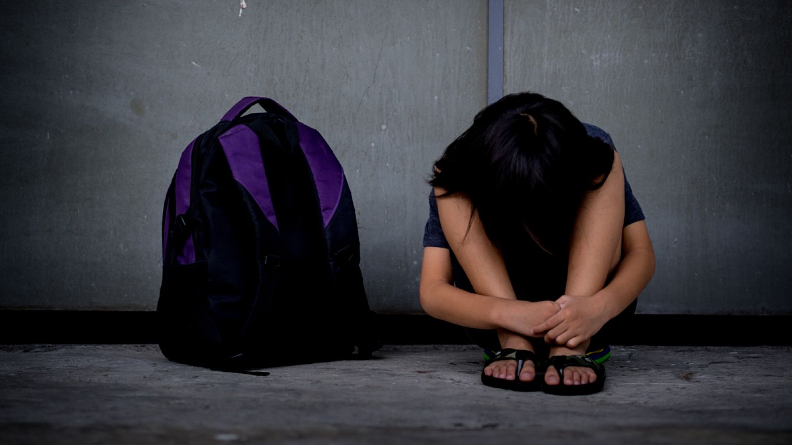 Fotografía de recurso de una niña sentada en el suelo.