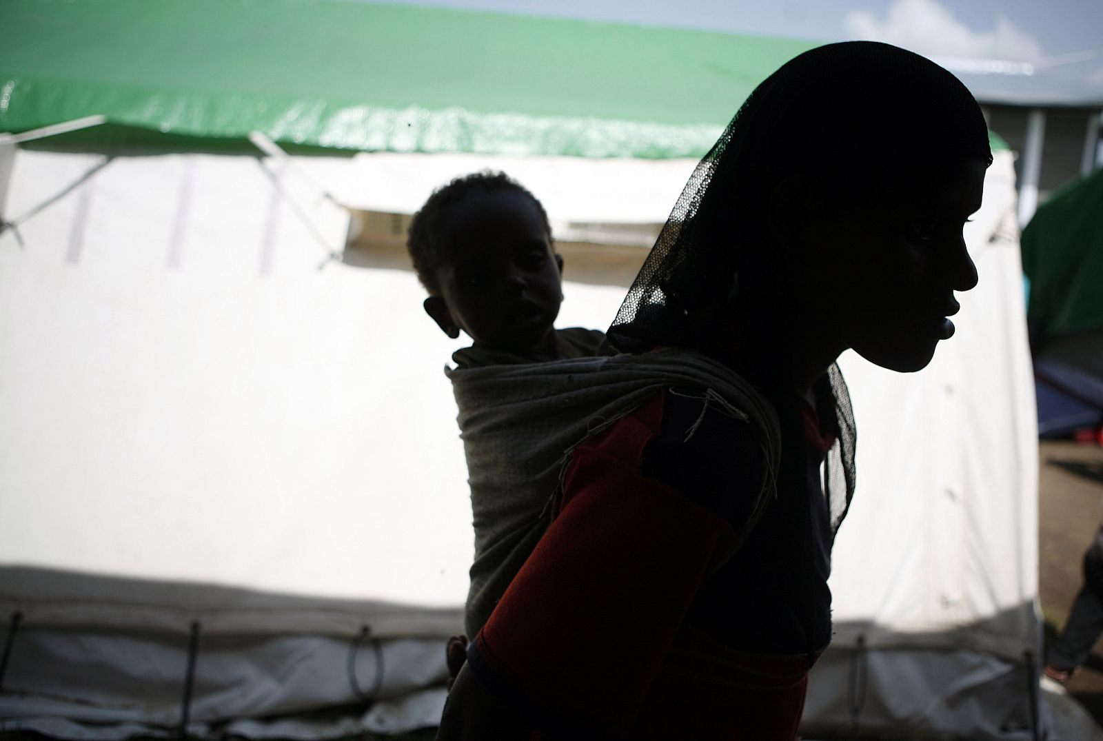 A mother carries her malnourished child in the yard of Medicine Sans Frontieres facility near Sheshemene