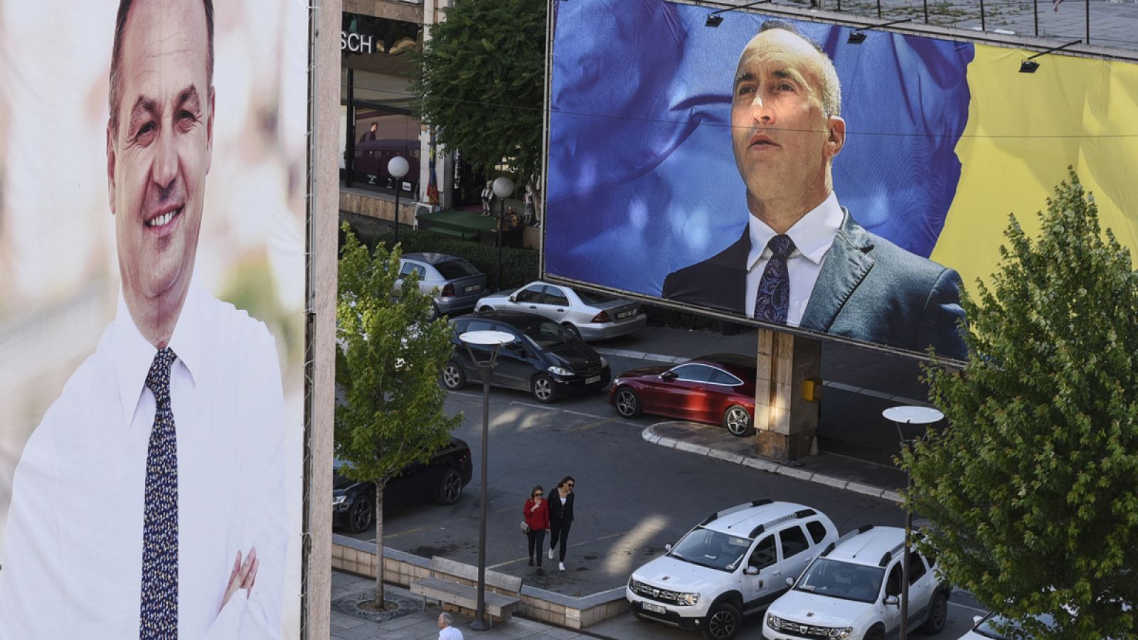 Los ciudadanos caminan entre pancartas electorales en Pristina.