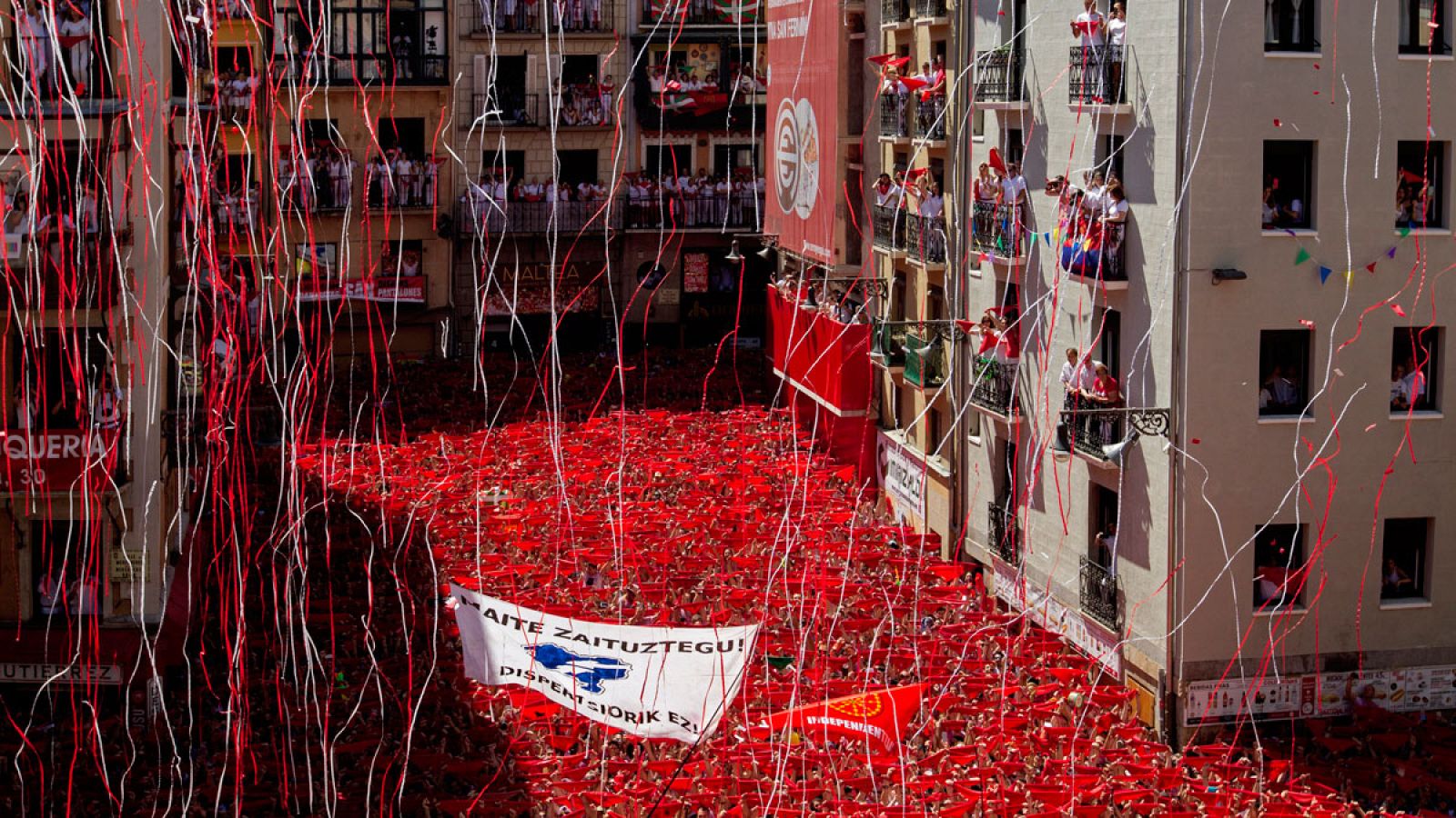 Miles de personas muestran el "pañuelico" en la Plaza del Ayuntamiento de Pamplona durante el chupinazo de 2016