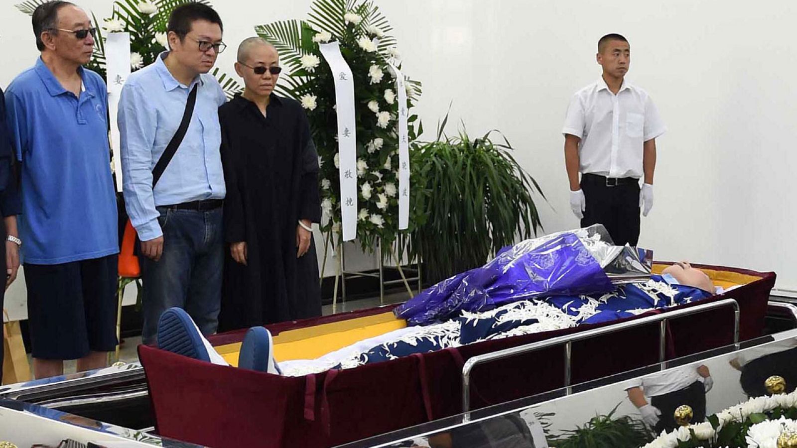 Liu Xia y otros familiares frente al ataúd abierto de Liu Xiaobo.