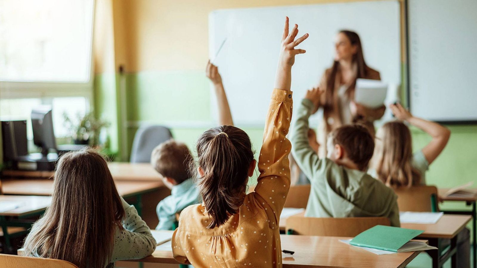 Niños atendiendo a su maestra en prácticas