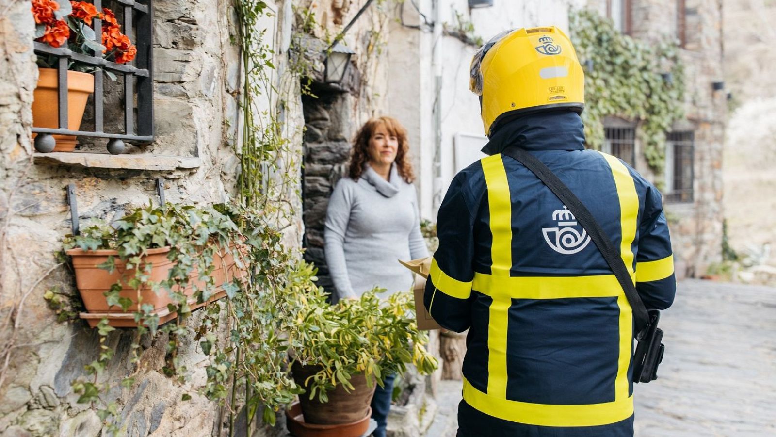 Un trabajador de correos atiende a residente de un municipio rural (EuropaPress)