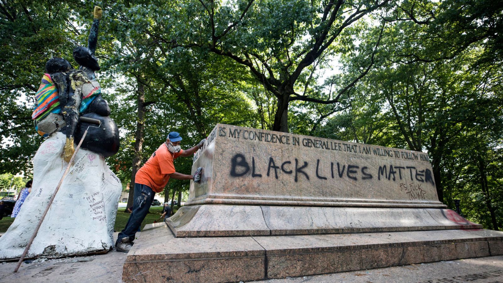 Un trabajador limpia un grafiti de la base del Monumento de Robert E. Lee y Stonewall Jackson tras la retirada de las estatutas en el parque Wyman, en Baltimore.