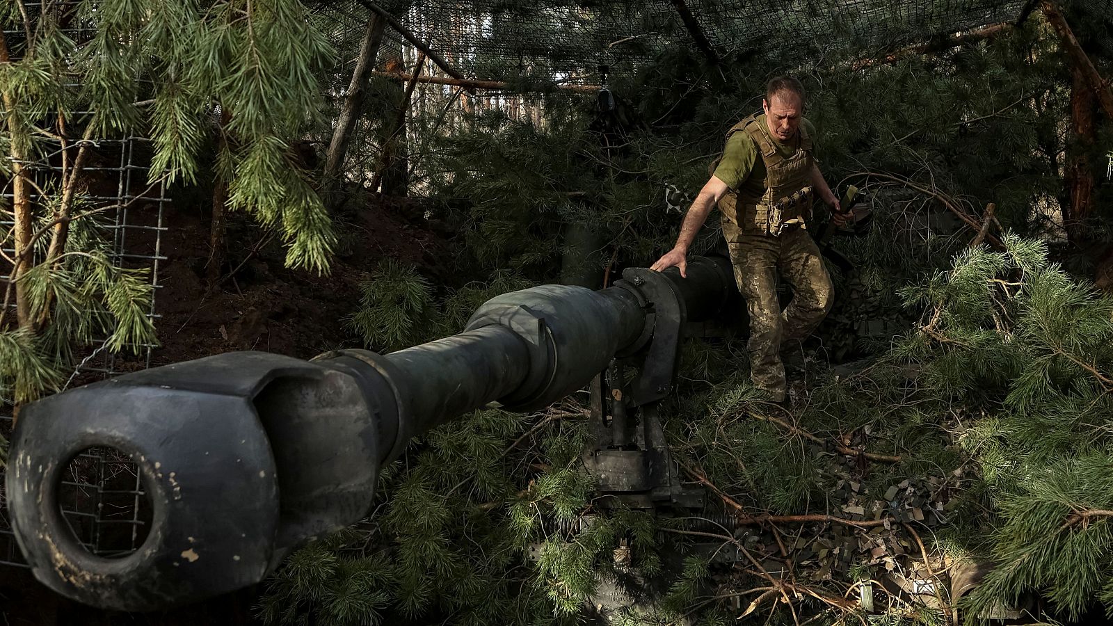Un militar ucraniano de la 93ª Brigada Mecanizada Separada "Kholodnyi Yar" camufla un obús autopropulsado M109