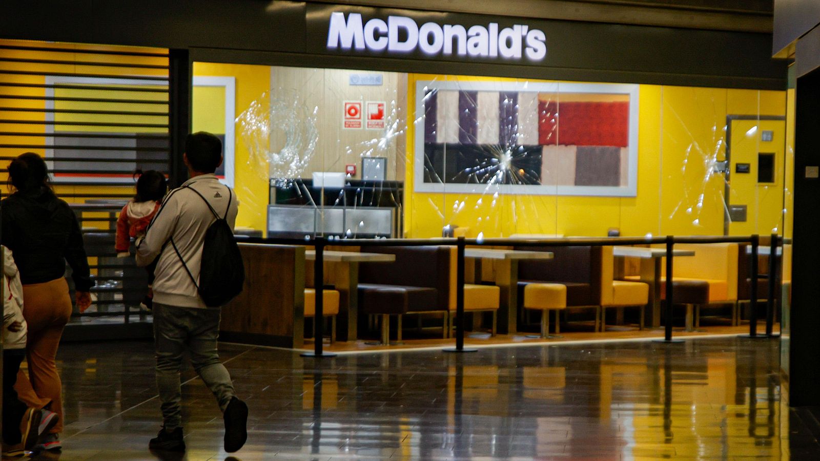 EuropaPress 5853350 dos personas pasan delante escaparate mcdonalds cristales rotos centro comercial