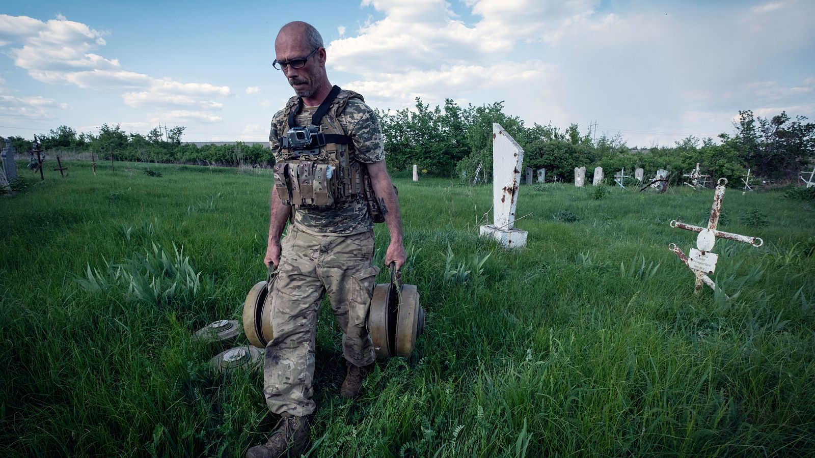 Un zapador ucraniano lleva minas después de limpiar el cementerio de la aldea de Krasnopillya