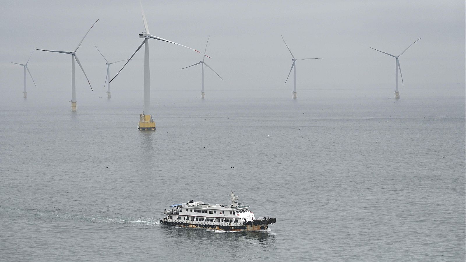 Un barco pasa junto a unas turbinas eólicas en la isla de Pingtan, el punto de China más cercano a la isla principal de Taiwán.