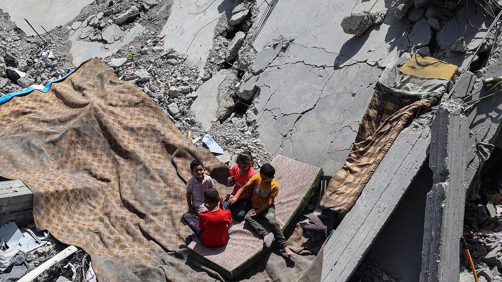 Niños palestinos entre las ruinas de un edificio en Gaza