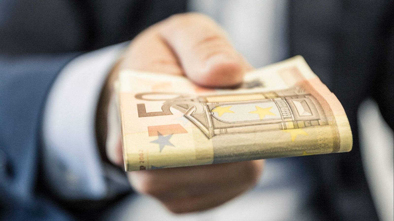 Una mano con billetes de euros.