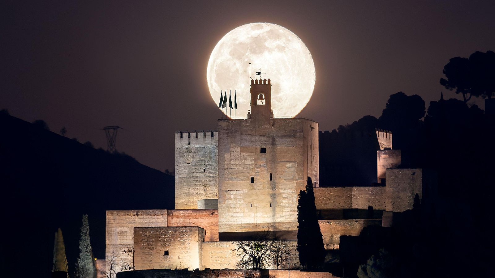 Luna llena, sobre la Torre de la Vela de la Alcazaba, en la Alhambra de Granada.