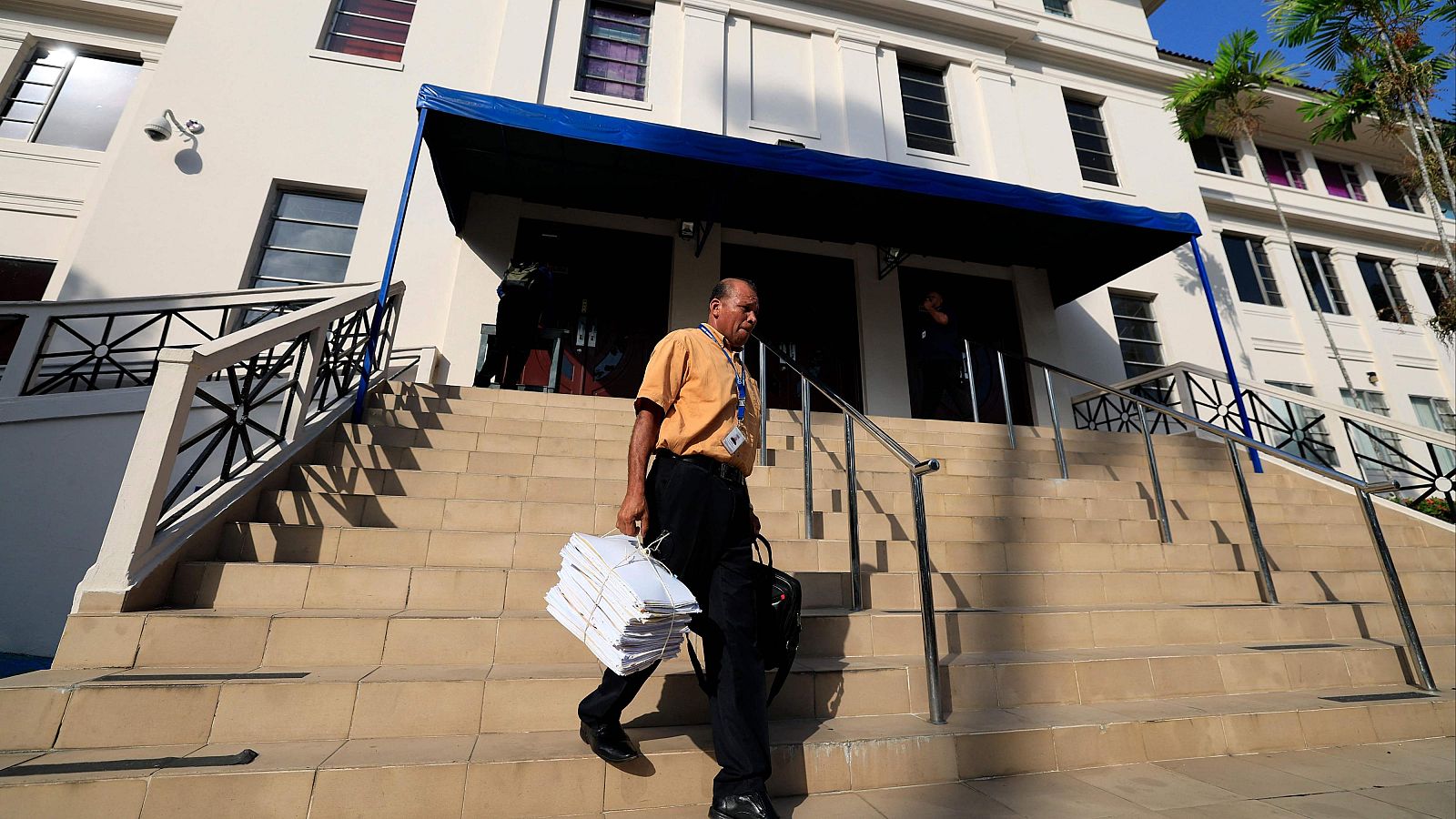 Un hombre lleva documentos fuera del juzgado donde se ha celebrado el juicio de los "Papeles de Panamá" en Panamá.