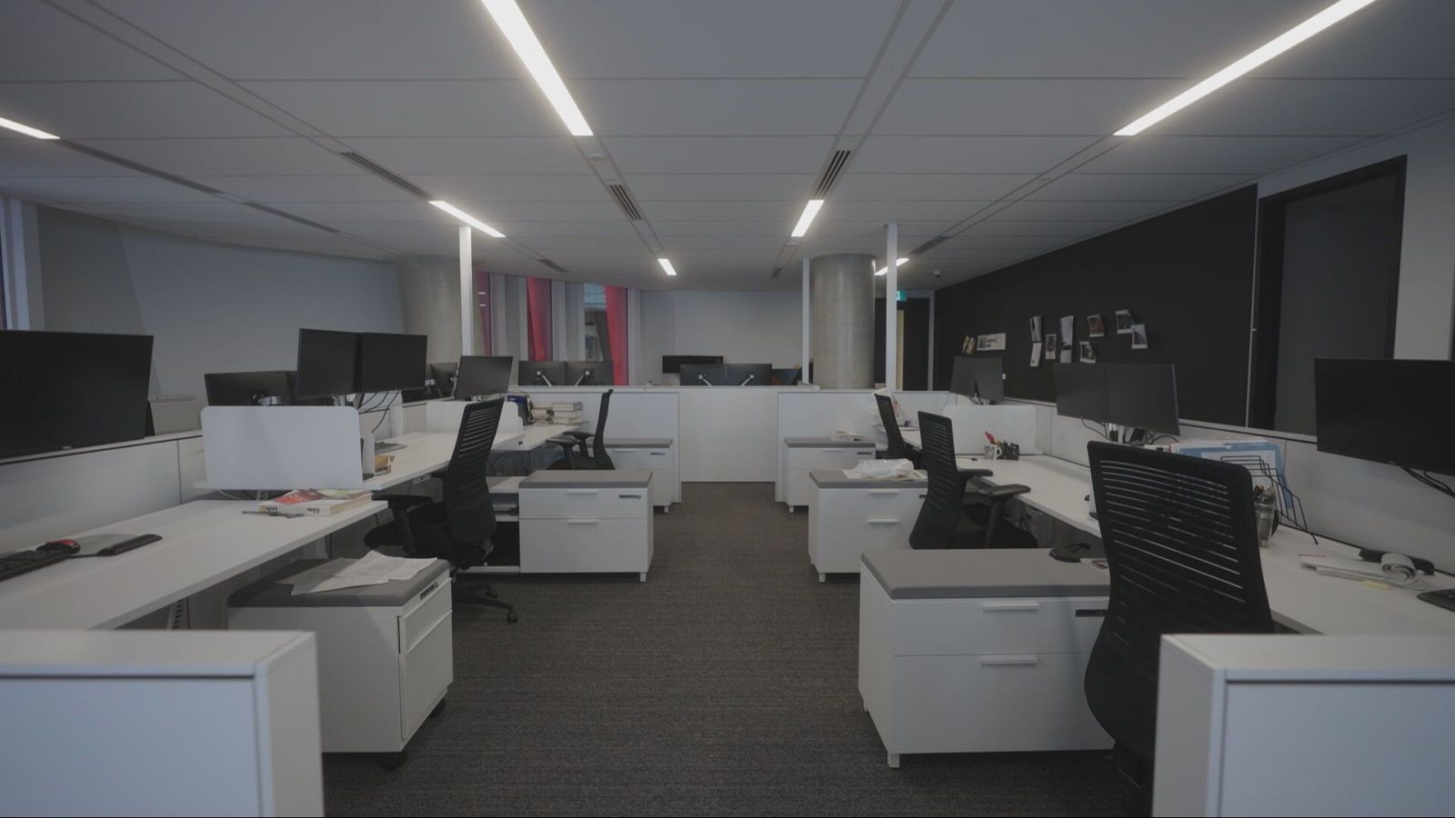 Mesas blancas y sillas negras en una oficina vacía