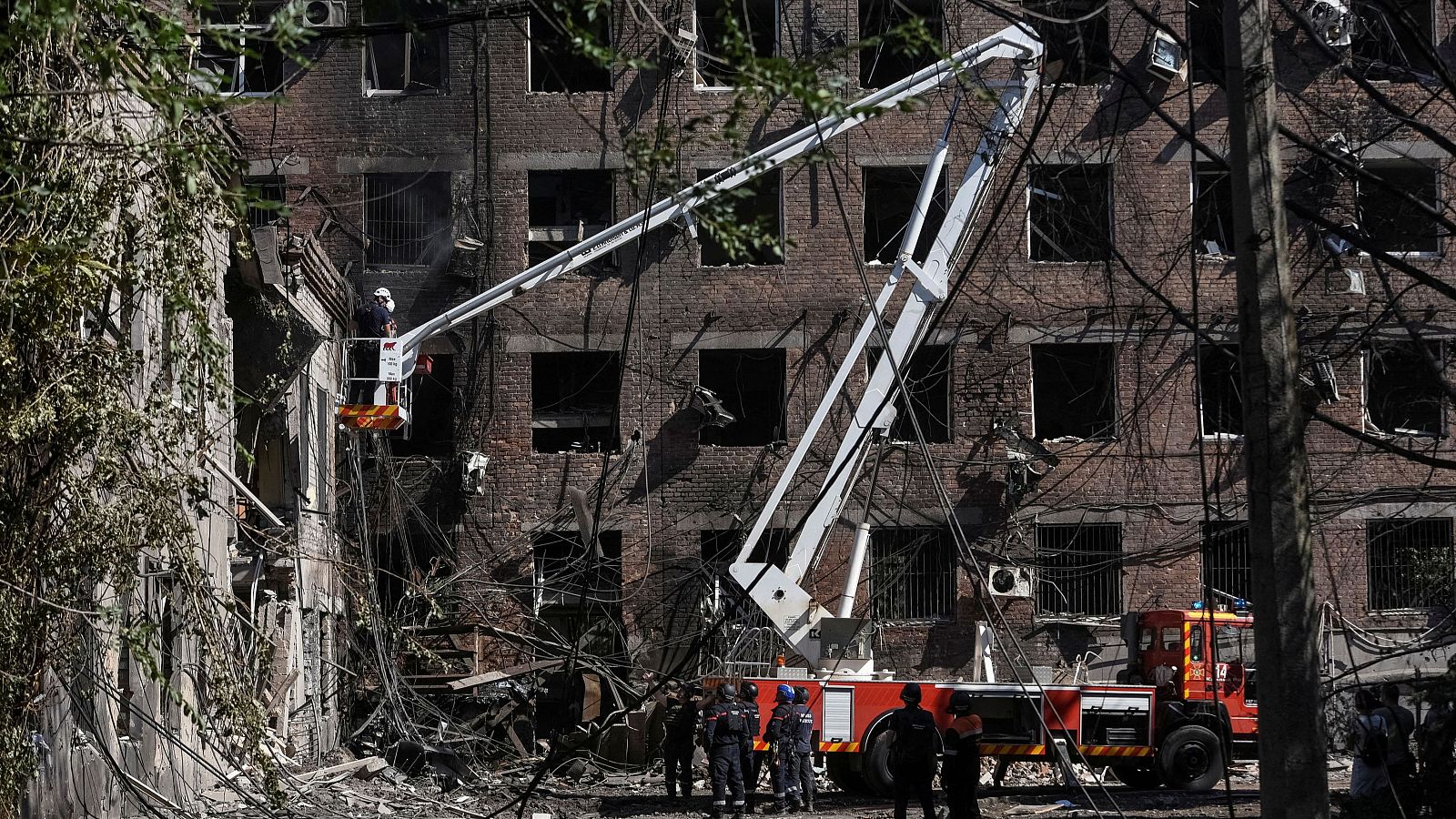 Bomberos ucranianos trabajan en un edificio de apartamentos alcanzado por un ataque con misiles rusos