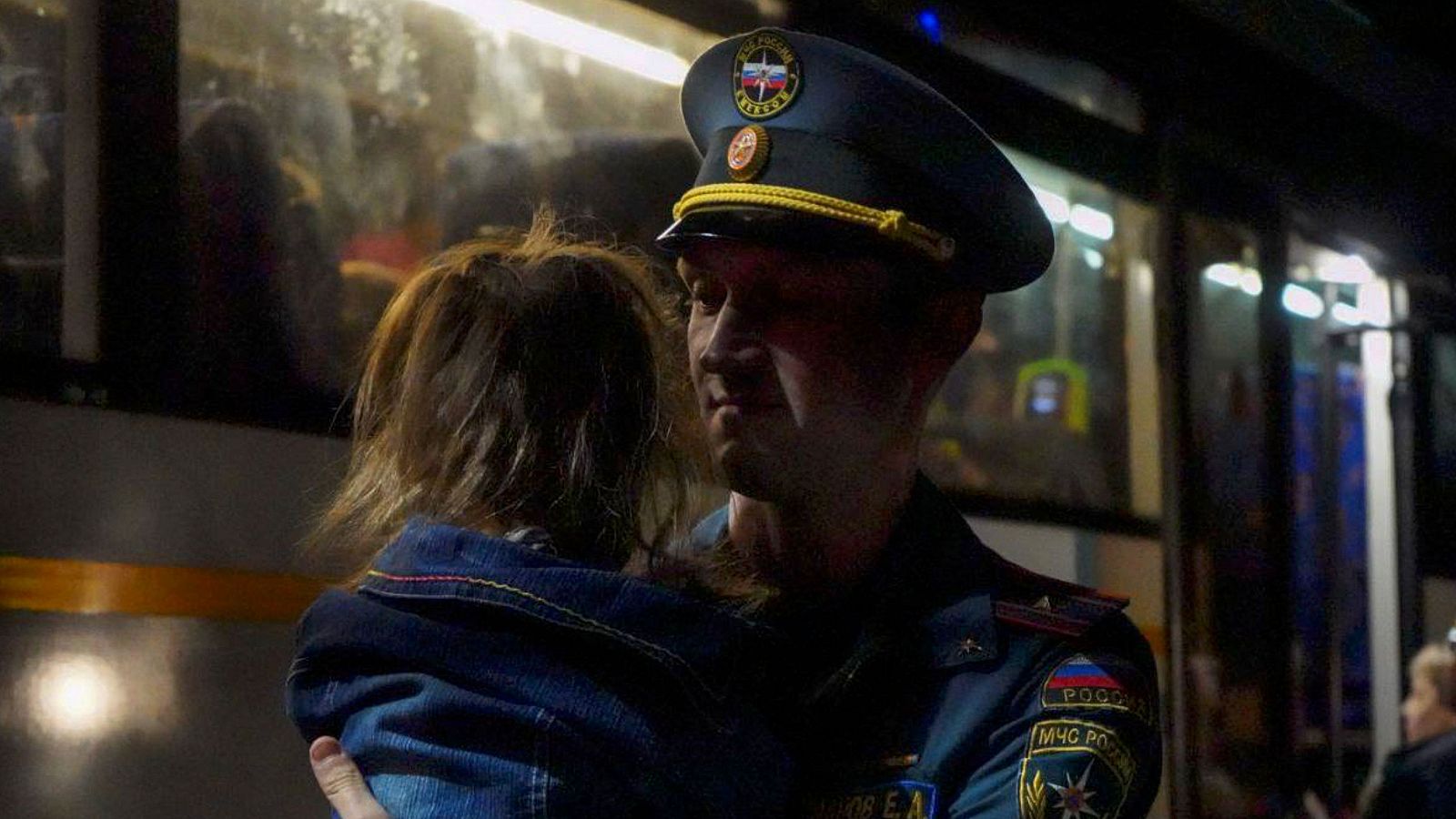 Un militar del Ministerio de Emergencias ruso ayuda a las personas que huyeron de los asentamientos fronterizos de la región de Kursk.