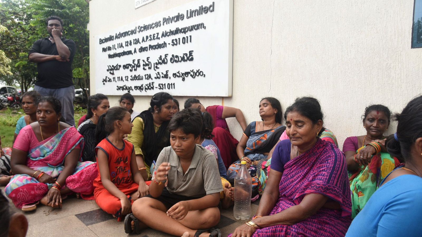 Familiares de las víctimas mortales del incendio provocado por una explosión en la farmacéutica Escientia Advanced Sciences Private Ltd., sentados frente a la fábrica, en Atchutapuram.