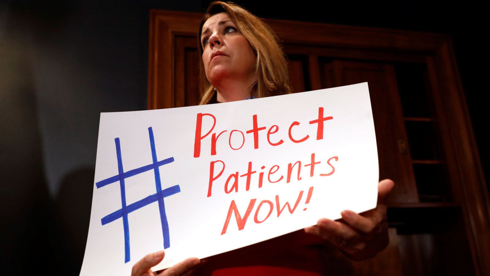 Una mujer protesta contra la reforma sanitaria: "Proteged a los pacientes ahora"