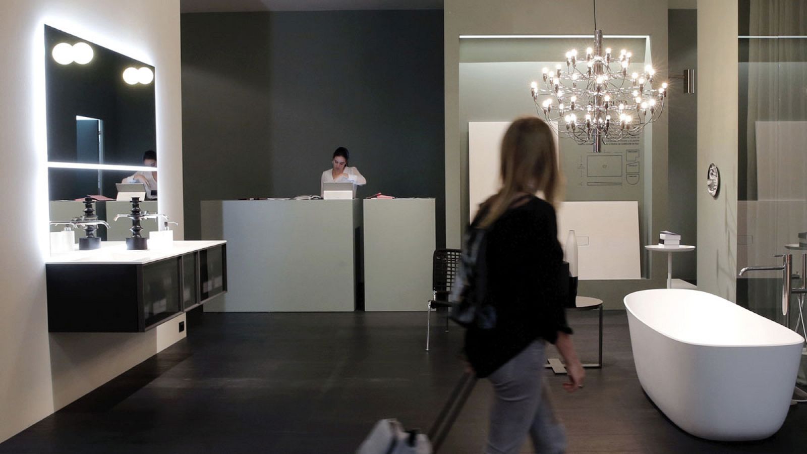 Una mujer mira un estand en una feria de muebles